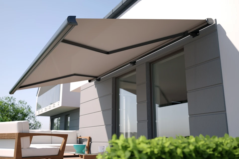 Maison contemporaine moderne au crépuscule avec terrasse en bois et mobilier d'extérieur